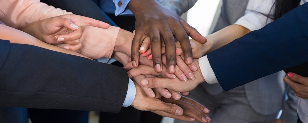 Photo of diverse team stacking hands