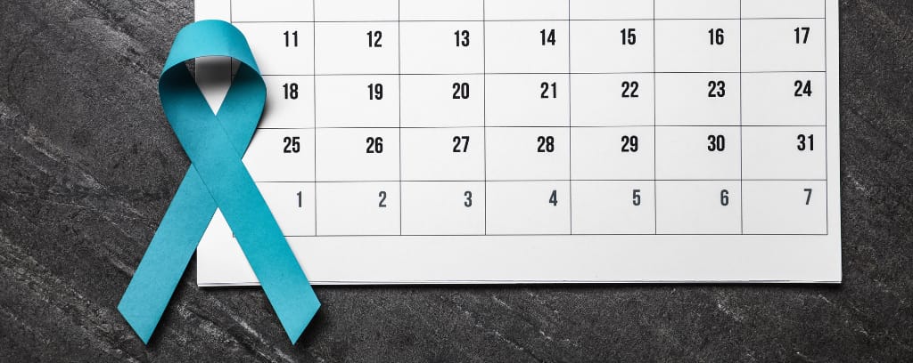 Photo of calendar with teal ribbon indicating it it Sexual Assault Awareness Month (SAAM).