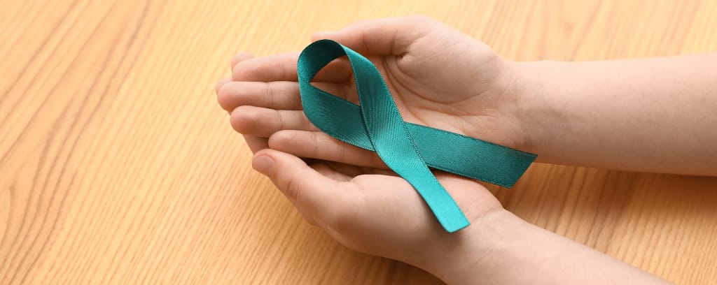 Photo of two hands cradling a teal ribbon